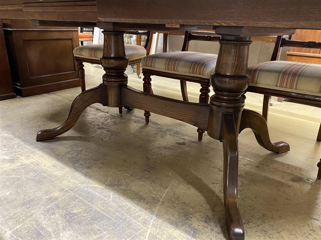 An 18th century style cross banded oak D end twin pillar extending dining table, 284cm extended, two spare leaves, width 130cm, height